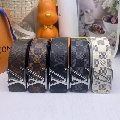 Five rolled leather belts in a row on a shelf, buckles facing out