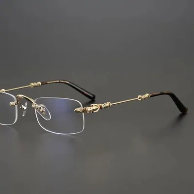 Rimless spectacles with thin gold temple arms on a dark background