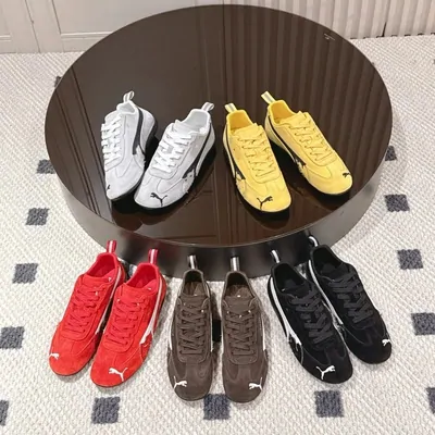 Seven pairs of low-top sneakers arranged face up on a round wooden table